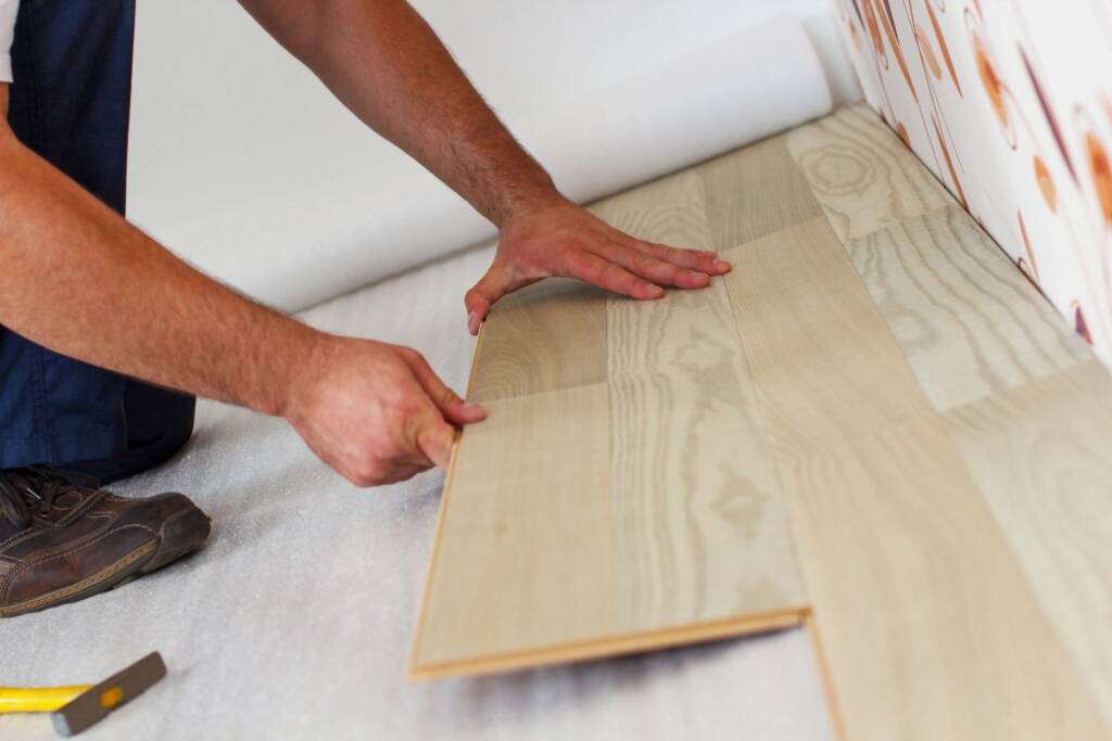 Flooring installer laying luxury vinyl plank flooring for CSI Carpet