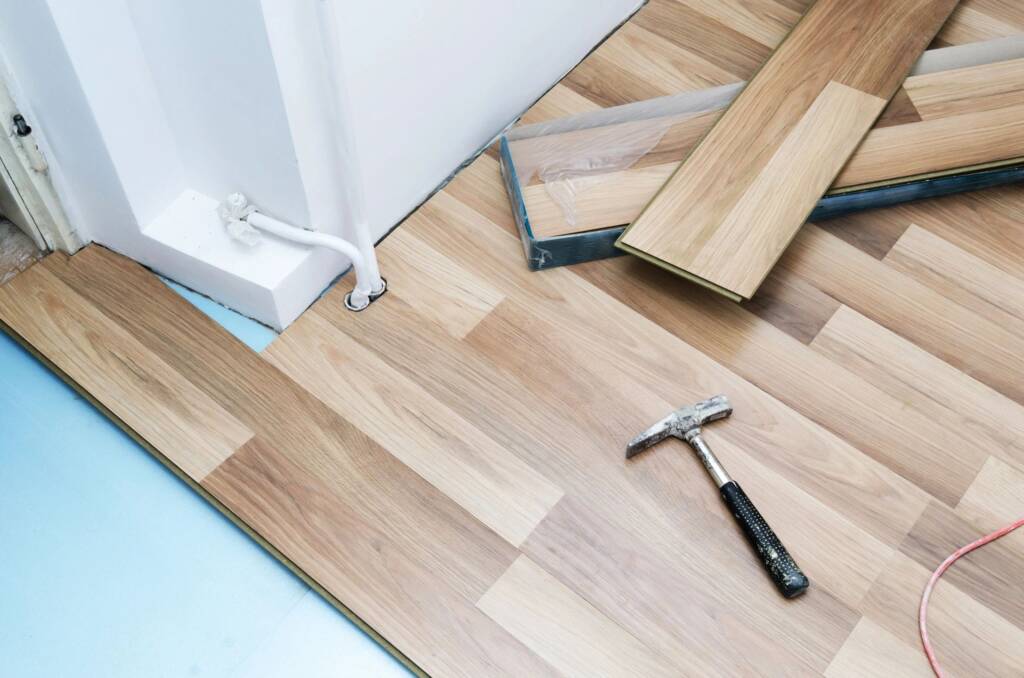 Luxury vinyl plank flooring installation and commercial flooring transitions in a hotel lobby.